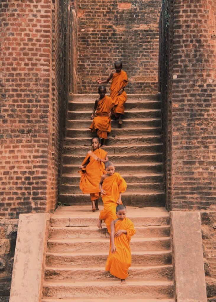 picture of five young monks walking down a temple in Sri Lanka